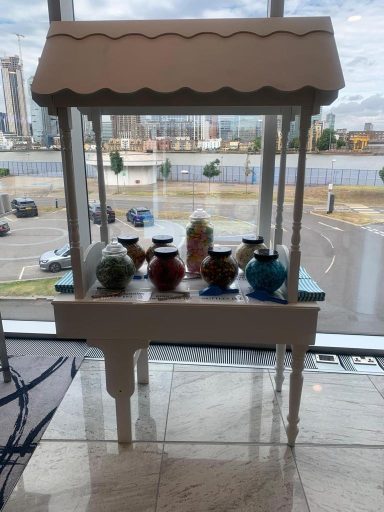 A decorative display table with colourful jars and a canopy.